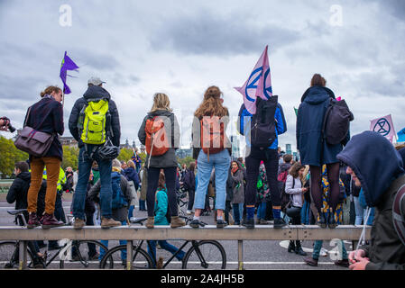 Rébellion Extinction stand manifestants avec des drapeaux sur le dessus d'une barrière de béton sur le pont de Westminster, Londres, 7 octobre 2019 Banque D'Images