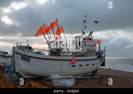 Hastings, East Sussex, UK. 15 octobre 2019. Drapeaux voltigent dans une pêche forte brise sur la vieille ville de Stade, sur un ciel nuageux tôt le matin, mais avec un beau jour prévu. Banque D'Images