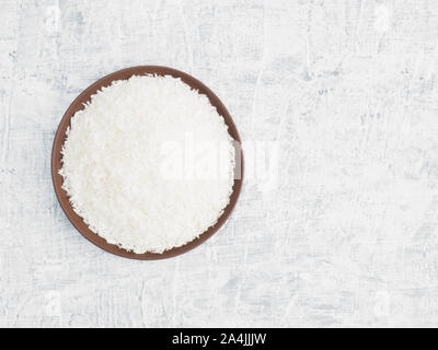 Épices aident à maintenir une bonne santé et à améliorer l'appétit, vue du dessus sur fond de béton. Flocons de noix de coco dans la plaque d'argile. La naturopathie, un apothicaire moderne Banque D'Images