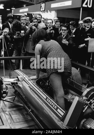 Modèle féminin en climing à Cooper F5000 à 1969 Racing Car show. Banque D'Images