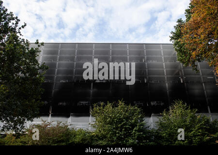 15 octobre 2019, en Rhénanie du Nord-Westphalie, Münster/Osnabrück : La façade d'un parking à étages à l'aéroport de Münster Osnabrück est assombri par la fumée. À l'aéroport de Münster Osnabrück (FMO), autour de 65 voitures a pris feu dans un parking à étages lundi soir. Photo : Bernd Thissen/dpa Banque D'Images