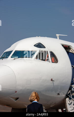 Hôtesse de l'air entrant dans l'avion, vue extérieure Banque D'Images