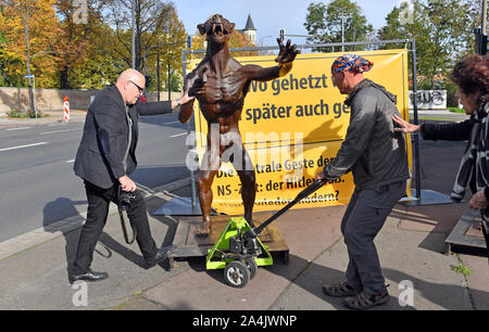 15 octobre 2019, la Saxe-Anhalt, Halle (Saale) : Rainer Opolka (r), artiste d'action, les positions l'un de ses quatre de bronze les loups en face du cimetière juif et la synagogue à Halle/Saale. Avec cette action, l'artiste de Brandebourg Opolka veut attirer l'attention sur l'augmentation de la violence d'extrême-droite. Dans le cadre d'une attaque programmée sur une synagogue à Halle, un homme de 27 ans a abattu deux personnes sur 09.10.2019. L'homme a avoué avoir commis l'attaque avec l'extrême droite et antisémite. Photo : Hendrik Schmidt/dpa-Zentralbild/dpa Banque D'Images