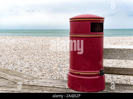 Une grande corbeille rouge vintage sur un trottoir de bois à une plage rocheuse Banque D'Images