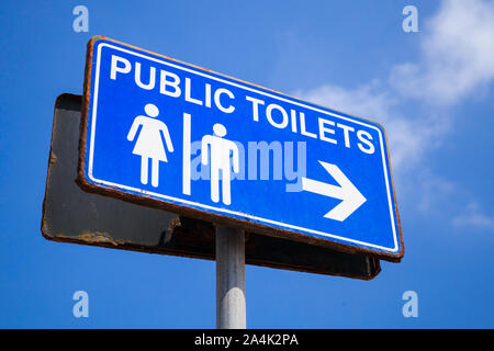 Toilettes publiques piscine signe sur tableau bleu par temps nuageux ciel bleu Banque D'Images