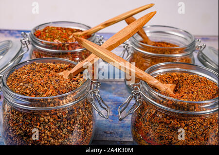 Épices parfumées dans un bocal en verre avec un couvercle métallique et d'un verrou sur une table en bois Banque D'Images