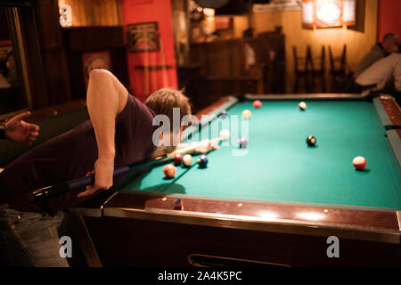 Homme jouant au billard dans la salle de billard Banque D'Images