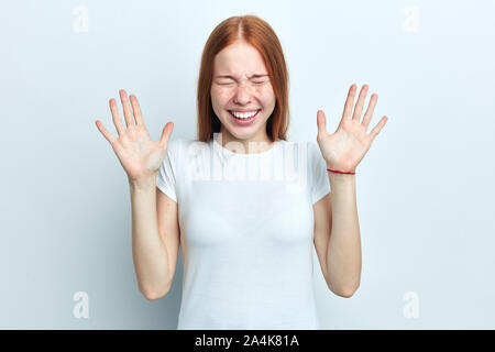 Happy crazy funny insouciante jeune femme garde les mains levées, dans l'esprit élevé, isolé sur fond blanc. Optimiste cheerful woman exprime p Banque D'Images