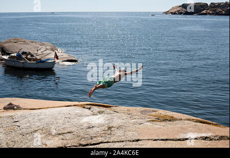 Jeune homme de plongée plongée de falaise, Vestfold, Norvège Banque D'Images