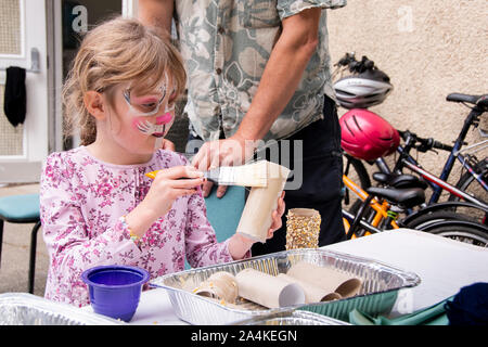 Sheffield, UK : 1 août 2016 : Une petite fille fait une mangeoire à partir de tubes de carton, le miel et les graines à l'église St Mary Family Fun Day Banque D'Images