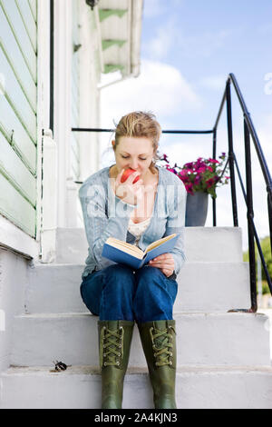 Femme, à l'extérieur de vieille maison de bois en Norvège Banque D'Images