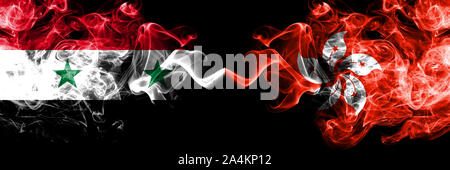 La Syrie contre Hong Kong, Chine drapeaux de fumée placés côte à côte. La fumée épaisse et soyeuse de couleur drapeaux de République et de Hong Kong, Chine Banque D'Images
