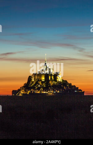 Allumé Le Mont Saint-Michel en Normandie France au coucher du Soleil avec ciel cramoisi spectaculaire Banque D'Images