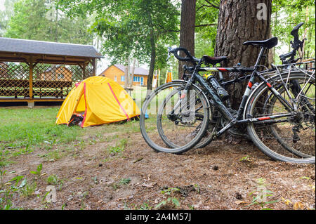 Les touristes cyclistes camping, deux vélos et un touriste jaune tente, Nesterovsky Marinovo village, district, région de Kaliningrad, Russie, le 1 août, 2019 Banque D'Images