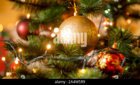 Photo gros plan de lots de Red et Golden baubles hanging on decorated Christmas Tree in living room Banque D'Images