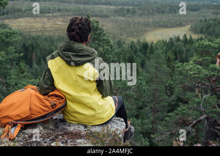 Woman sitting on rock Banque D'Images