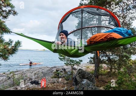 Man resting in hammock at lakeshore Banque D'Images