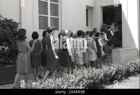 Les années 1960, historiques, un groupe de nouveaux étudiants de première année, excité les jeunes filles dans une file devant l'entrée d'un bâtiment à l'Université de Californie du Sud (USC), Los Angeles, États-Unis, dans un viist à leur nouvelle maison. Banque D'Images