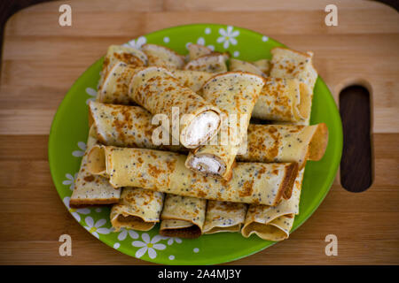 Rouleaux de crêpes avec du fromage cottage. Des crêpes au fromage sur une planche de bois. Maslenitsa. Banque D'Images
