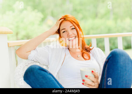 Jeune femme reposant sur balcon Banque D'Images