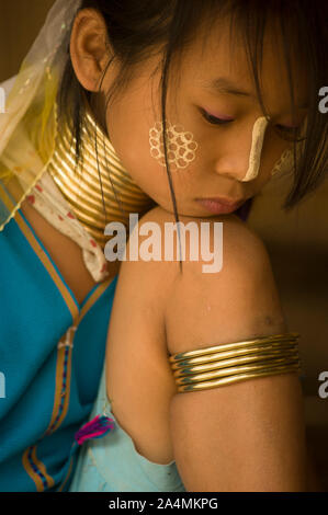 Chiang Mai, Thaïlande - 20 mai 2011 : jeune fille dans la tribu Karen long cou assis avec menton sur son genou - vertical image Banque D'Images