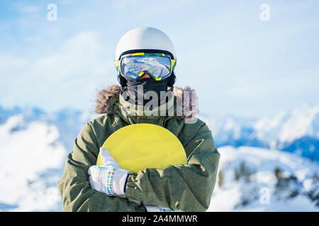 Portrait d'homme en casque avec snowboard debout sur snow resort sur journée d'hiver Banque D'Images