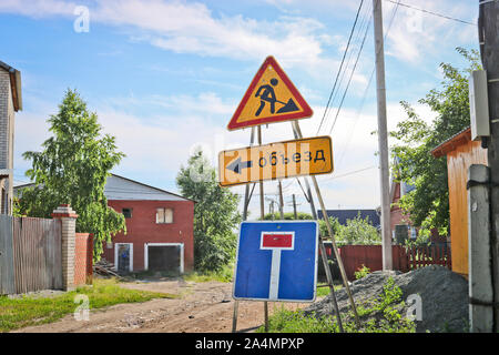Panneau routier réparation de routes, pas d'allée, avec l'inscription en russe "détour". Dans un village en construction Banque D'Images