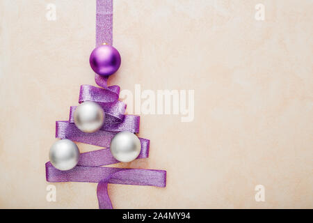 Arbre de Noël à partir de ruban violet, argent et boules rouges sur fond pastel rose , concept de l'époque de Noël, d'hiver, le nouvel an. Télévision lay, t Banque D'Images