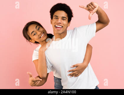 Joyful couple having fun et prenant photo sur appareil photo imaginaire Banque D'Images