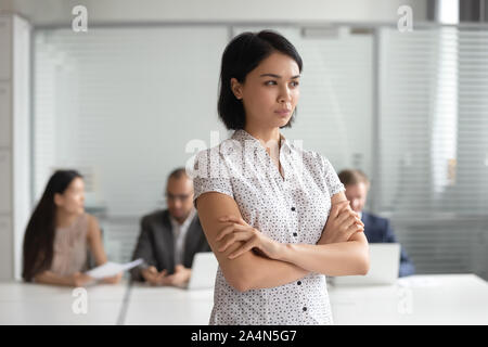 Mécontents en colère Asian businesswoman with arms crossed standing in office Banque D'Images