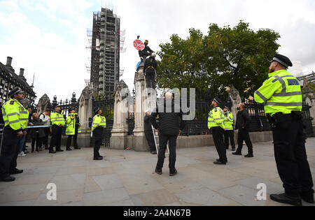 Une rébellion d'extinction se trouve sur manifestant au pilier de clôture chambres du parlement à Londres. Banque D'Images