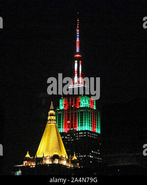 New York, New York, USA - 1 janvier 2016 : le sommet de l'Empire State Building se trouve à s'allumer en vert et rouge pour Noël derrière l'or haut de la C Banque D'Images