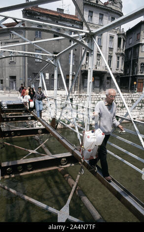 5 juin 1993 pendant le siège de Sarajevo : les musulmans bosniaques traversez prudemment ce qu'il reste de l'Ćumurija Bridge, sur leur façon de chercher de l'eau potable. Banque D'Images