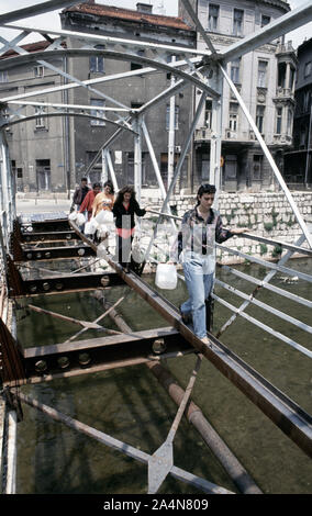 5 juin 1993 pendant le siège de Sarajevo : les musulmans bosniaques traversez prudemment ce qu'il reste de l'Ćumurija Bridge, sur leur façon de chercher de l'eau potable. Banque D'Images