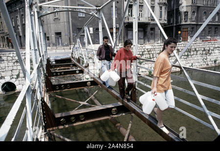 5 juin 1993 pendant le siège de Sarajevo : les musulmans bosniaques traversez prudemment ce qu'il reste de l'Ćumurija Bridge, sur leur façon de chercher de l'eau potable. Banque D'Images