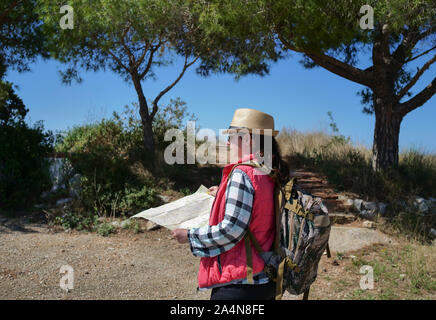 Voyageur fille avec un sac à dos et une carte va le long de la route. Bonjour Banque D'Images