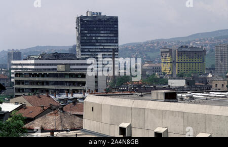 5 juin 1993 pendant le siège de Sarajevo : la vue au nord-ouest d'Stolačka Street. L'holocauste de la tour de l'Édifice de l'Assemblée parlementaire de la Bosnie-Herzégovine domine le cadre avec l'hôtel Holiday Inn sur la droite. En face de l'Assemblée générale, sont les ruines de l'ancienne usine de tabac. Banque D'Images