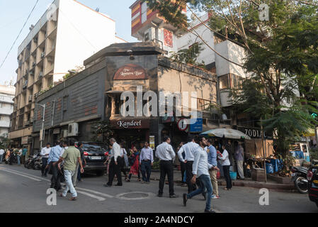 Les amateurs de bureau à pied en face de Kandeel restaurant dans la région de fort de Mumbai, Inde. Ceci est également connu comme l'art district de Mumbai. Banque D'Images