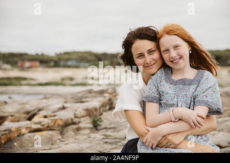 Mère et fille embrassant à seaside Banque D'Images