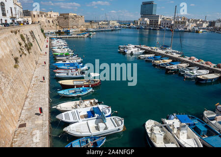 Bateaux amarrés dans le port à côté de l'ancien mur de la ville dans la vieille ville de Gallipoli, Puglia (Pouilles) dans le sud de l'Italie Banque D'Images