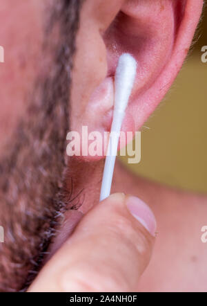 Homme nettoie les oreilles avec des tampons de coton Banque D'Images