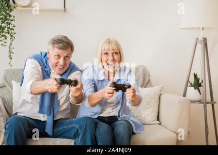 Joyful senior couple having fun, à jouer à des jeux vidéo Banque D'Images