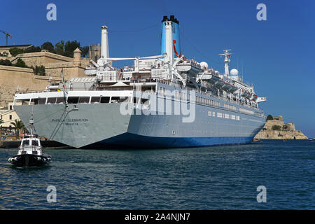 Le bateau de croisière amarré Célébration Marella à La Valette, Malte avec un bateau-pilote venant aux côtés Banque D'Images