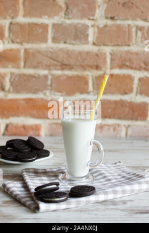 Les cookies au chocolat sucré avec la crème vanille et un verre de lait. Banque D'Images