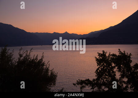 De soleil colorés sur le lac de Côme, Menaggio, au vu de la côte de Varenna, Italie. Banque D'Images