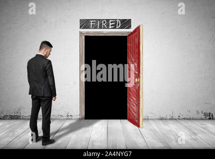 Businessman standing in front of une porte ouverte avec l'obscurité derrière elle Banque D'Images