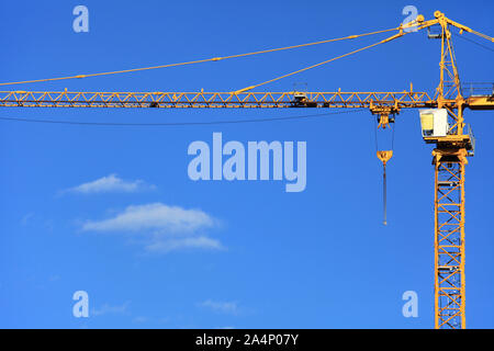 Grue de construction unique sur le fond de ciel bleu. Site de construction avec grue. La construction d'immeubles modernes Banque D'Images