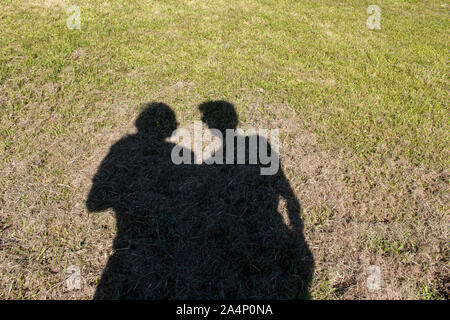 Ombre d'une femme et l'homme dans un champ vert Banque D'Images