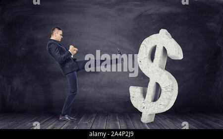 Homme d'affaires en pleine croissance donne le coup d'énorme signe dollar béton Banque D'Images