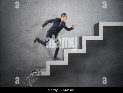 Businessman running up escalier en béton, qui est l'écrasement vers le bas après lui Banque D'Images